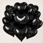 Cluster of black heart-shaped balloons on a plain background