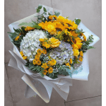 Bouquet of sunflowers, hydrangeas, and yellow roses wrapped in white paper