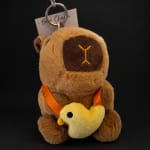 Plush bear keychain holding a small yellow duck charm