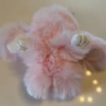 Pink fluffy bunny plush with white ears and gold accents