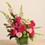 Pink roses and carnations in a square glass vase