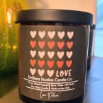 Black candle jar with a heart-pattern label and the word LOVE