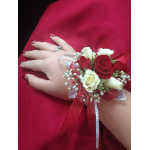 Hand corsage with red and white roses on a red background