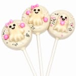Three ghost-shaped cake pops with pink bows and sprinkles