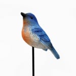 Decorative blue and orange bird figurine on a black stake