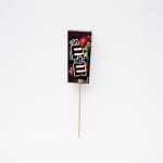 M&M's candy package on a wooden pick against a white background