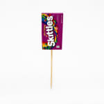 Skittles candy package mounted on a wooden pick