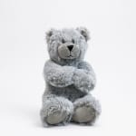 Gray teddy bear plush toy sitting on a white background