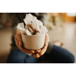 Hands holding a white bowl filled with wrapped chocolates