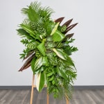 Tall tropical plant arrangement on a wooden easel with layered green foliage