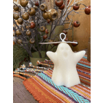 White ghost-shaped candle on a colorful woven cloth