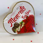 Heart-shaped chocolate box with red roses and nuts