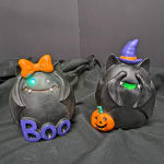 Two black Halloween cat figurines with a bow and witch hat