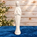 White praying figure figurine on a blue surface