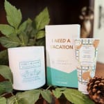 Gift set with a candle, shower steamers box, and hand cream tube