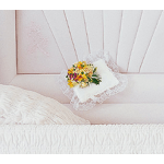Small floral pillow with lace trim on a pink bedspread