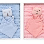 Two boxed baby blankets with teddy bear faces, one blue and one pink