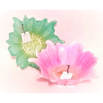 Two decorative glass flower-shaped bowls, one green and one pink
