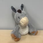 Gray plush donkey toy sitting on a table
