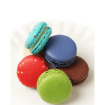 Assorted colorful macarons stacked on a white surface