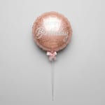 Pink birthday balloon with a ribbon and clear stick