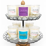 Set of scented candles in glass jars on a two-tier wire stand