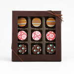 Box of assorted chocolates with patterned tops in a brown gift box