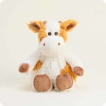 Plush cow stuffed animal sitting on a plain background.