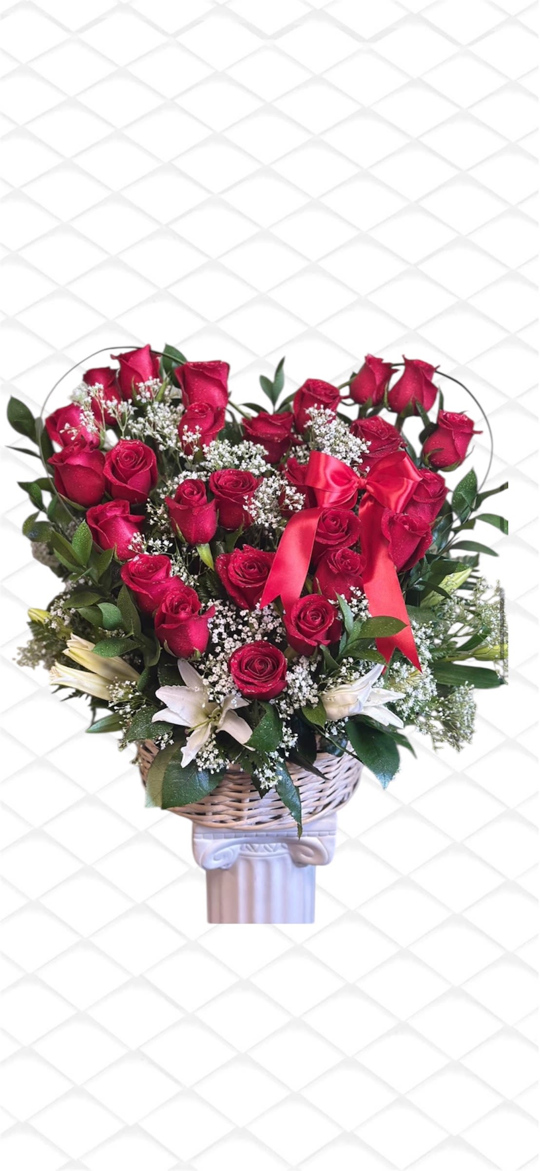 Red rose bouquet with white filler flowers in a wicker basket