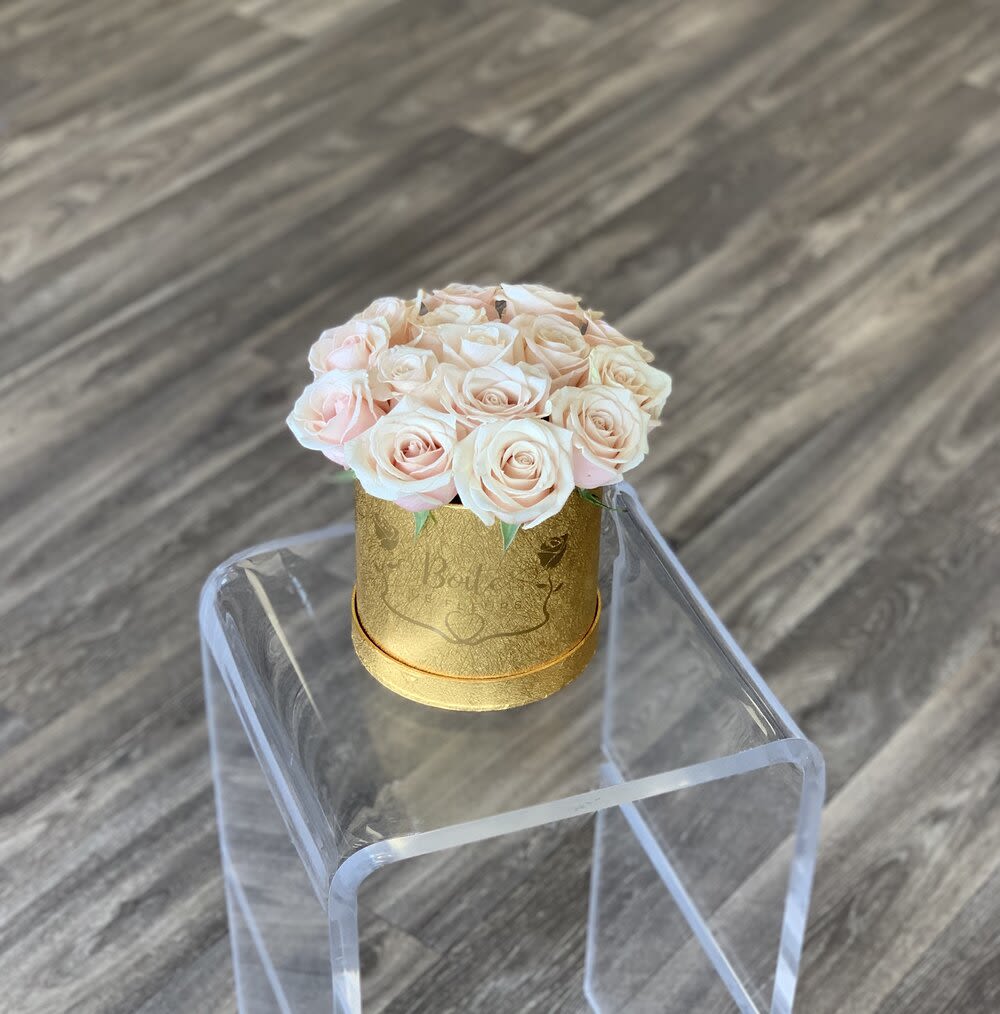 Small bouquet of pale pink roses in a gold round box