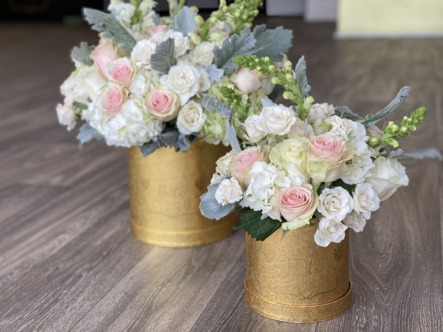 Two pastel rose arrangements in gold boxes