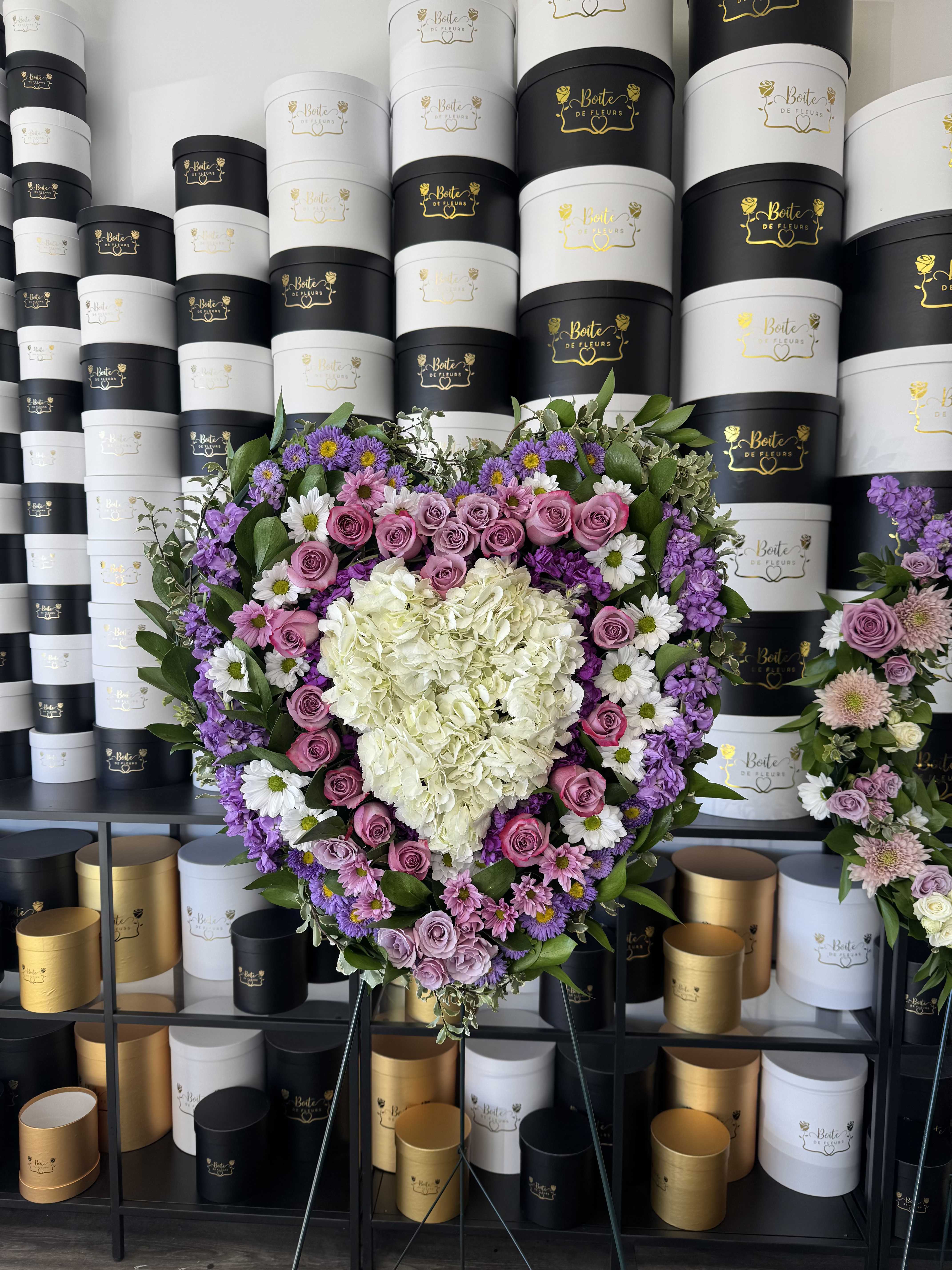 Heart-shaped floral arrangement with pink roses, white hydrangea, and purple flowers