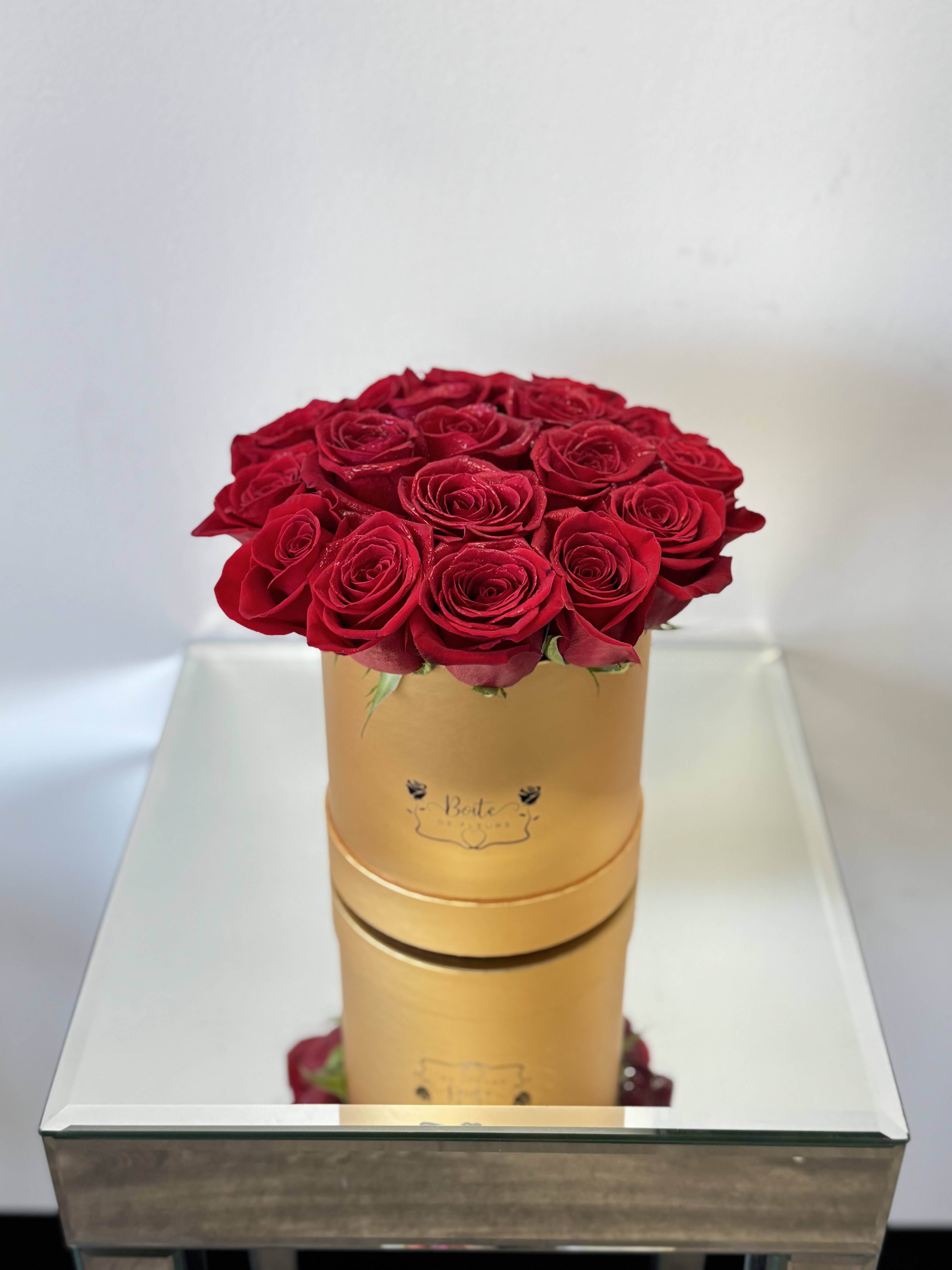 Red roses arranged in a gold round box