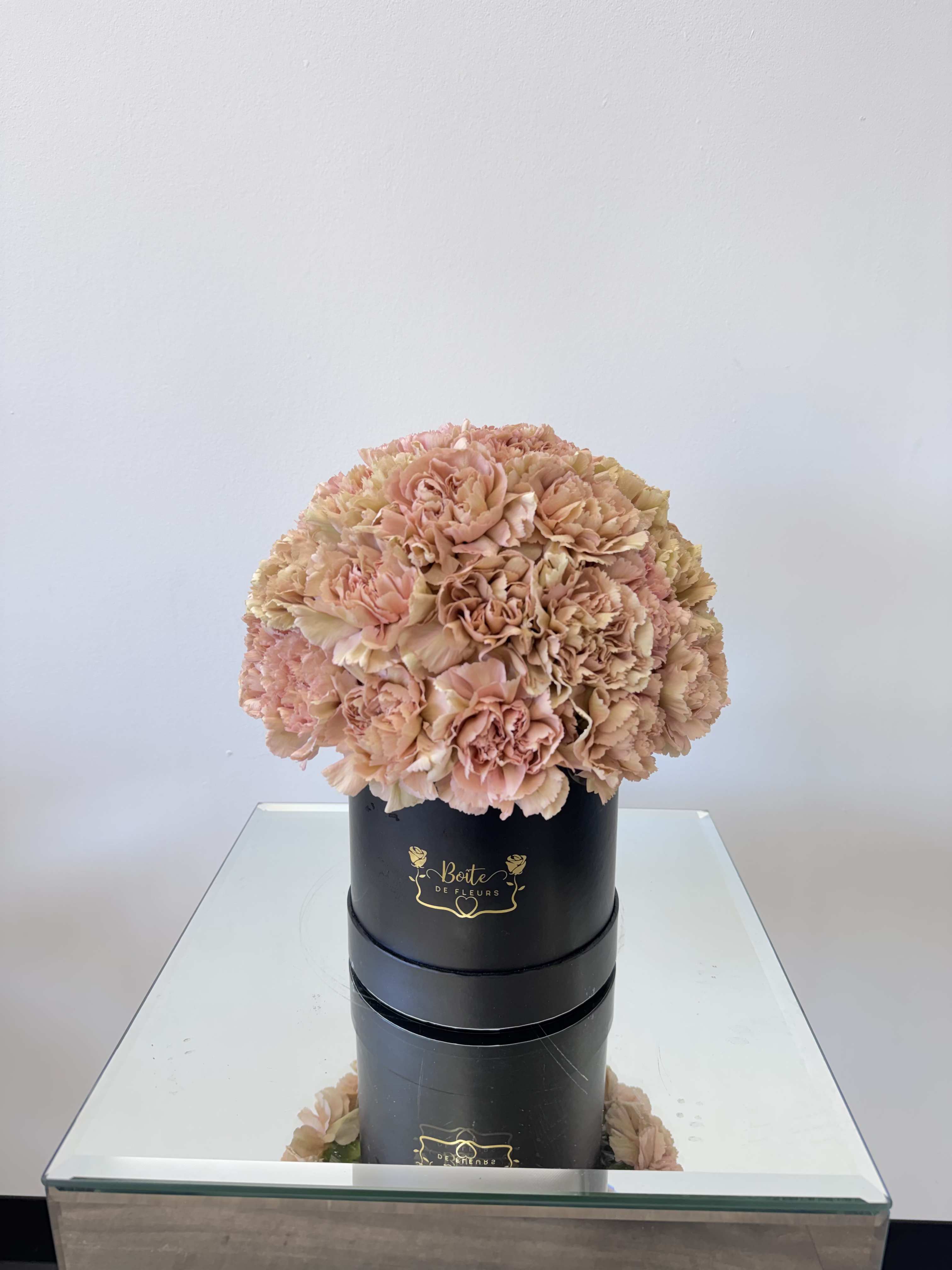 Peach carnation bouquet in a black hatbox