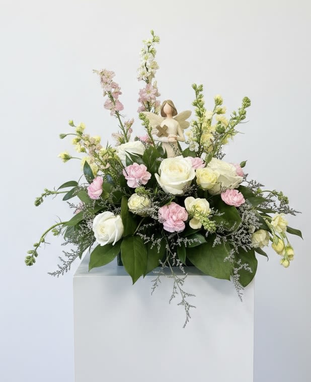 Pastel floral arrangement with roses and carnations on a pedestal