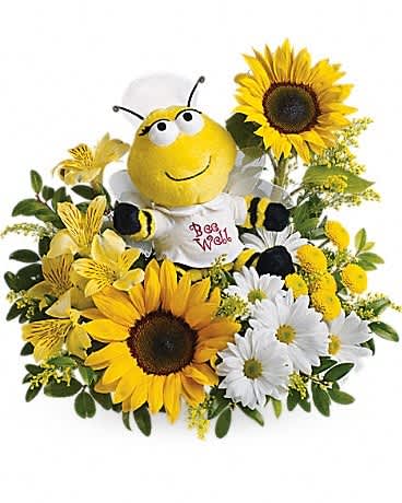 Cheerful arrangement of sunflowers and white daisies with a plush bee toy in the center