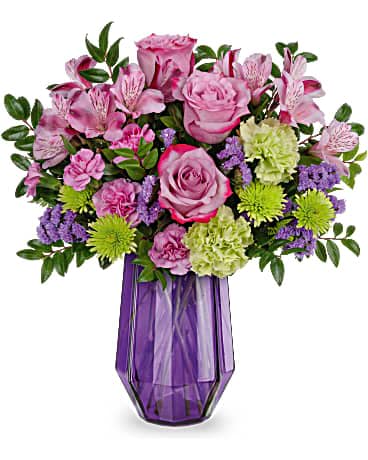 Mixed bouquet of pink roses and green mums in a faceted purple glass vase