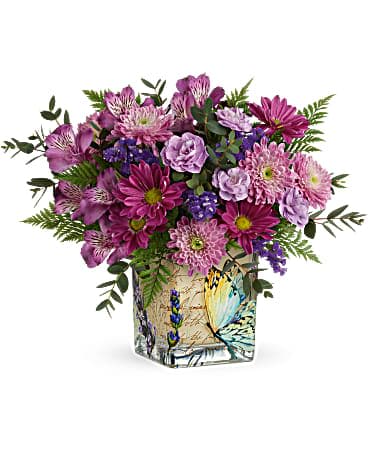 Purple and pink mixed bouquet arranged in a square glass vase with a butterfly design