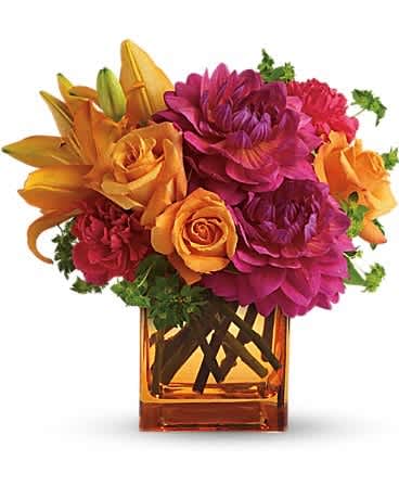 Square orange vase of orange lilies and roses with bright pink dahlias and red carnations.