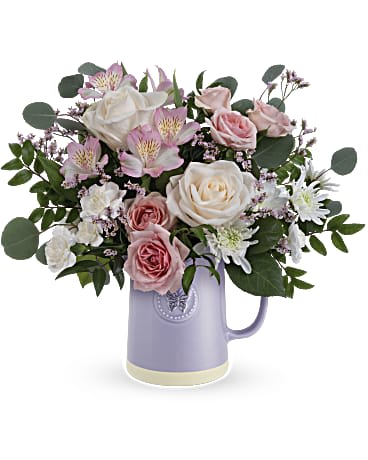 Pastel pink and white mixed bouquet arranged in a lavender ceramic pitcher-style vase