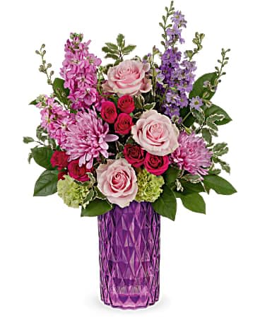 Tall purple vase with pink roses, mums, spray roses, and purple flowers