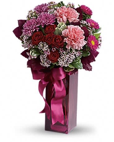 Tall berry-toned bouquet with pink carnations, red roses, and purple mums in a magenta vase