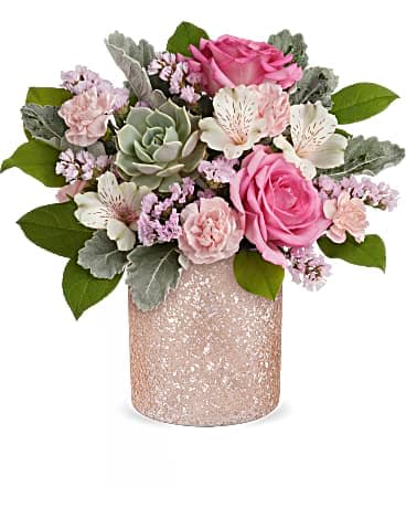 Short arrangement of pink roses, carnations, and a green succulent in a glittery pink vase