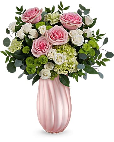 Teleflora's Sweetheart Twist Bouquet - Indulge Mom with the allure of soft pink roses and vibrant greens, beautifully nestled in our pearlescent glass vase for an unforgettable Mother's Day gesture.. Surprise Mom with a lush arrangement of green hydrangeas, pink roses, white spray roses, and accents of green carnations, chrysanthemums, lush silver dollar eucalyptus, and huckleberry, elegantly displayed in our pearlescent glass vase this Mother's Day.