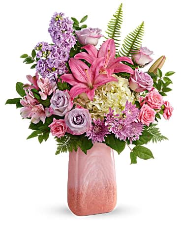 Pink and lavender bouquet with lilies, roses, and hydrangea in a tall pink ceramic vase