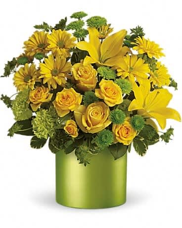 Arrangement of yellow roses, lilies, and daisies in a green cylinder vase