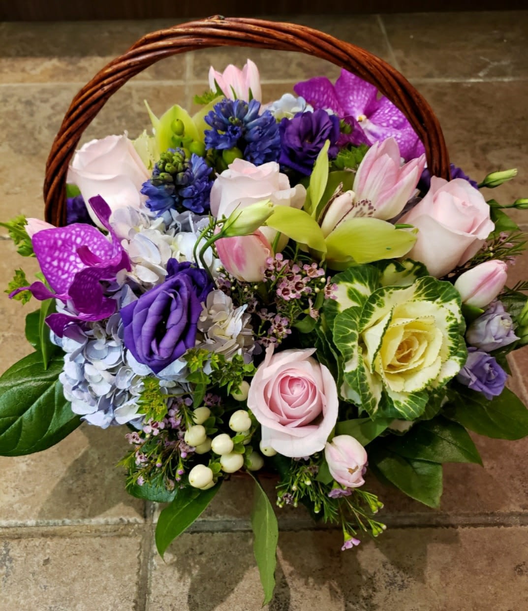 Basket of pink, purple, and blue flowers with roses and lilies