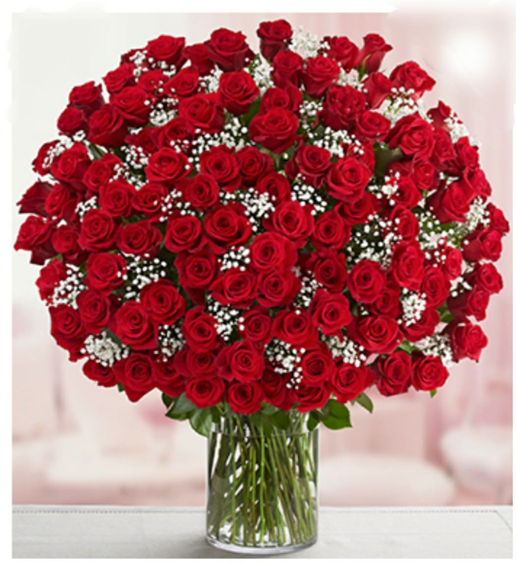 Large bouquet of red roses with baby's breath in a clear glass vase