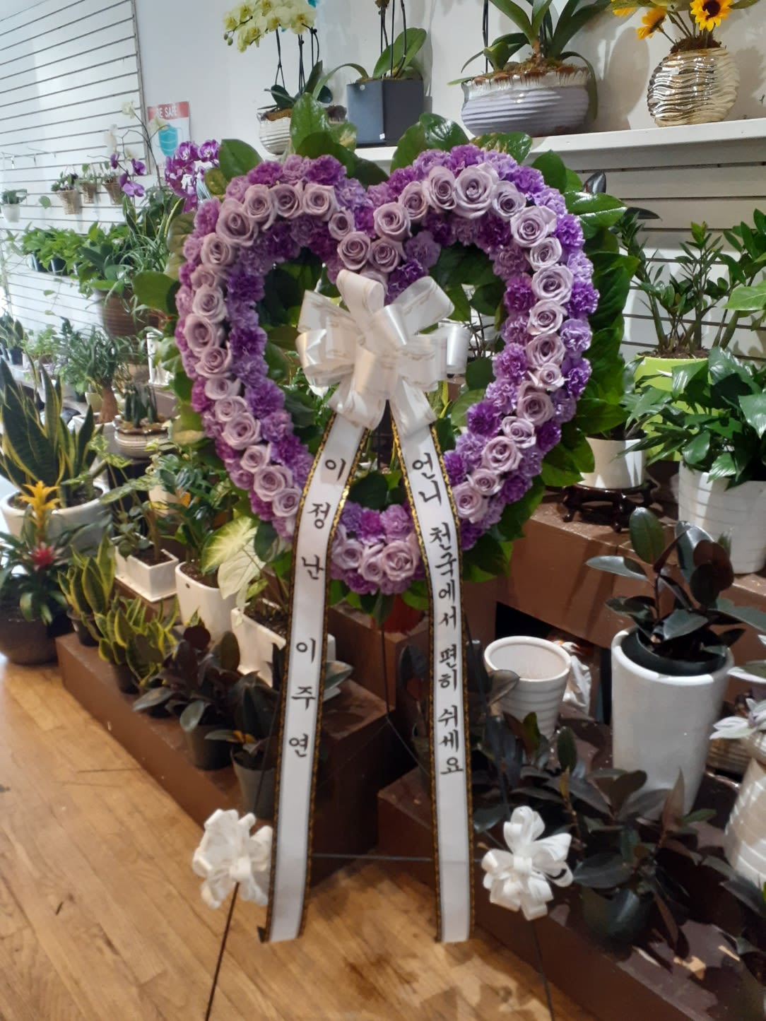 Purple heart-shaped floral wreath with ribbon streamers