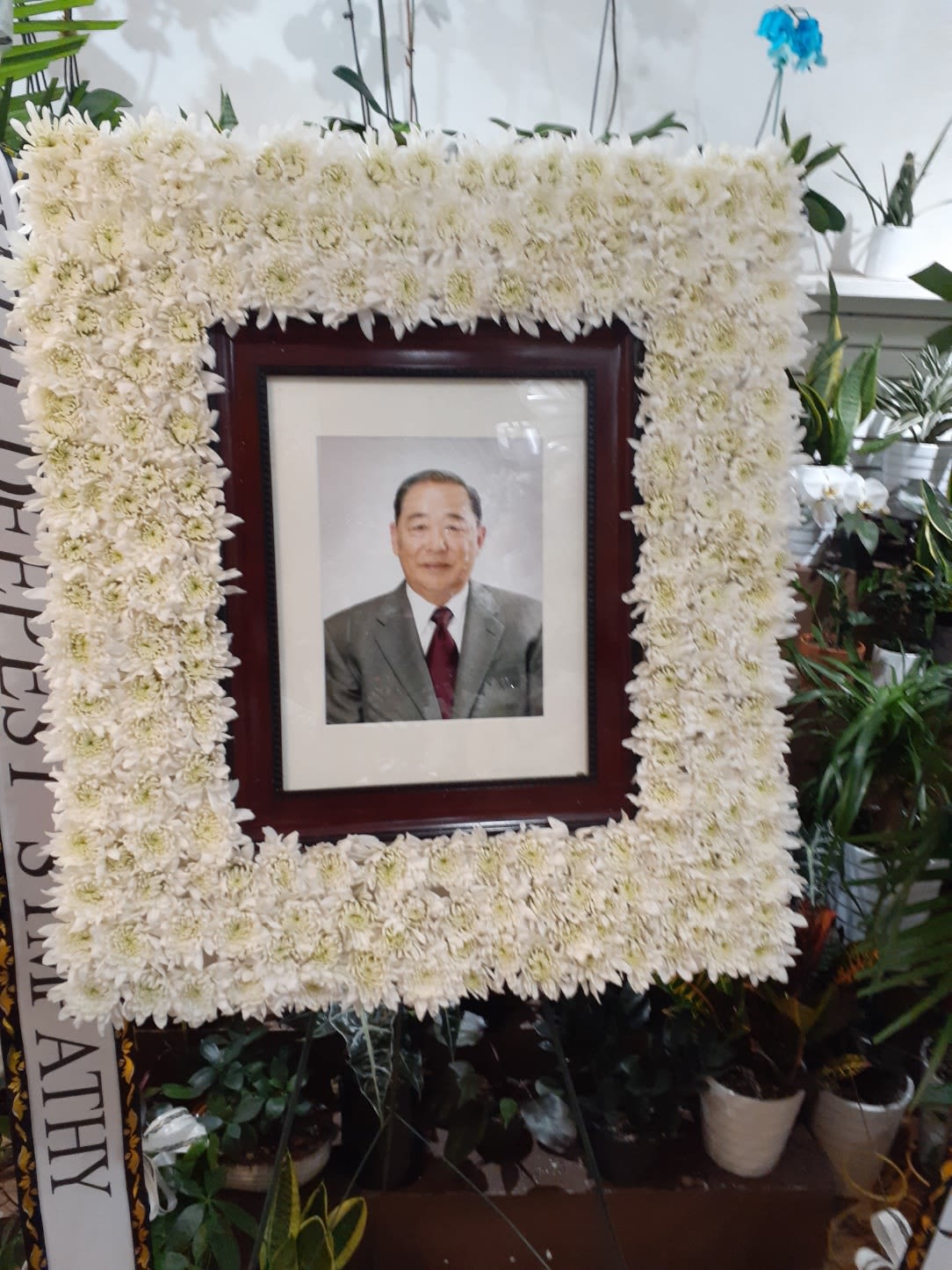 White chrysanthemum funeral frame surrounding a portrait